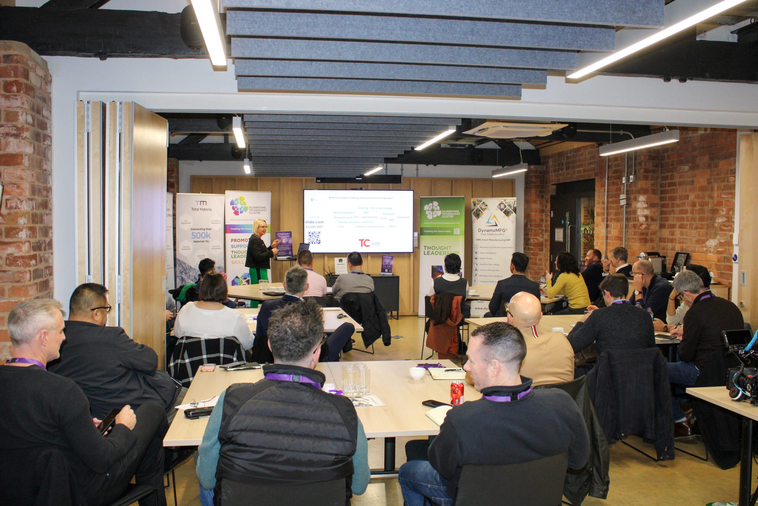 People attending technology business presentation in conference room.